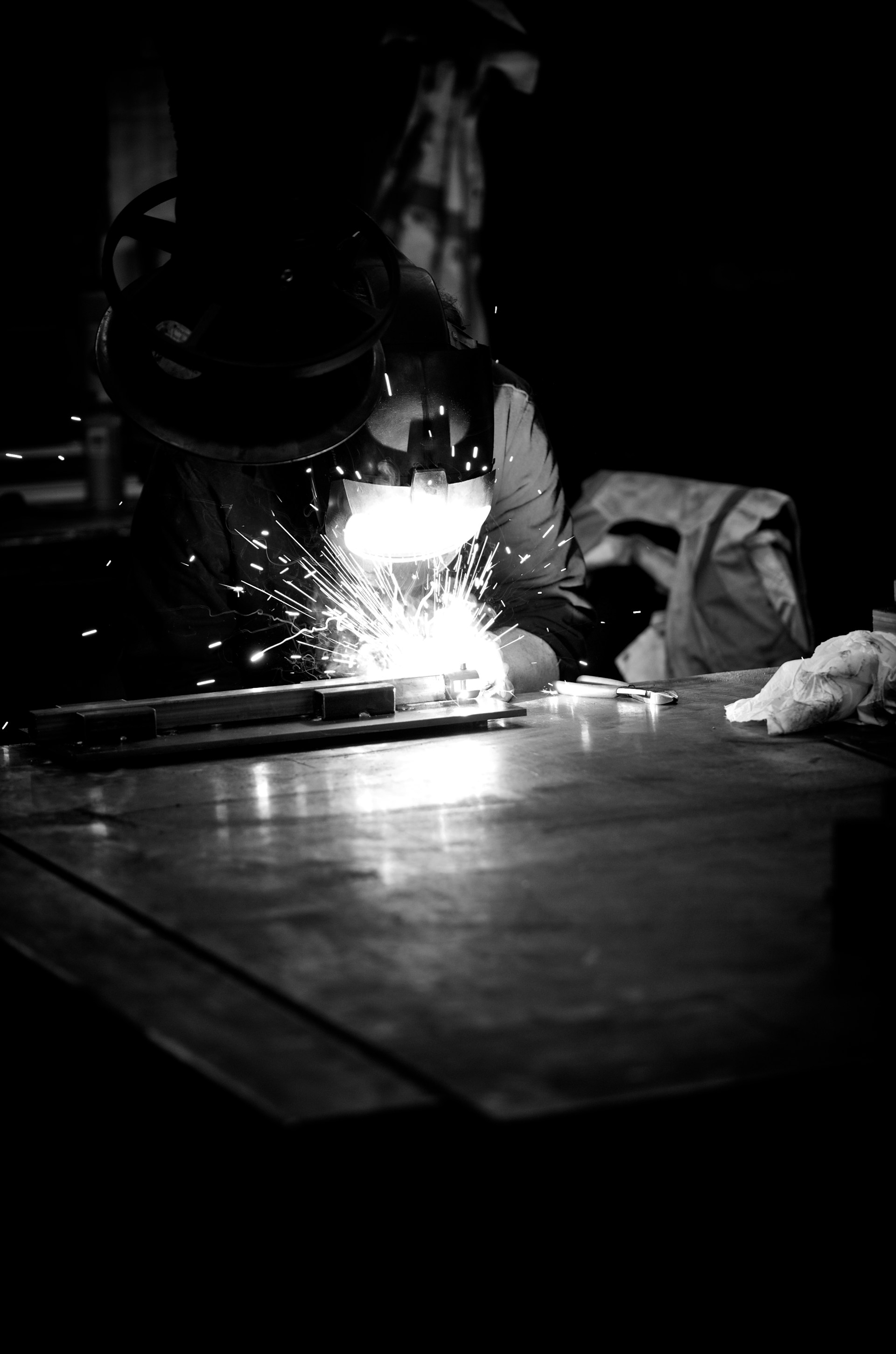 Welding sparks during structural steel fabrication in a workshop environment